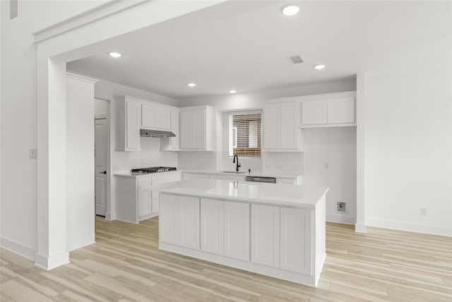 kitchen featuring a kitchen island, light wood-type flooring, and white cabinetry