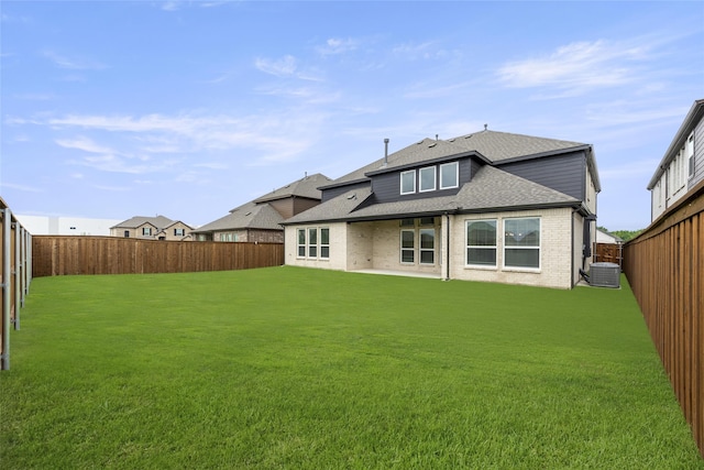 back of house featuring a yard and central AC unit