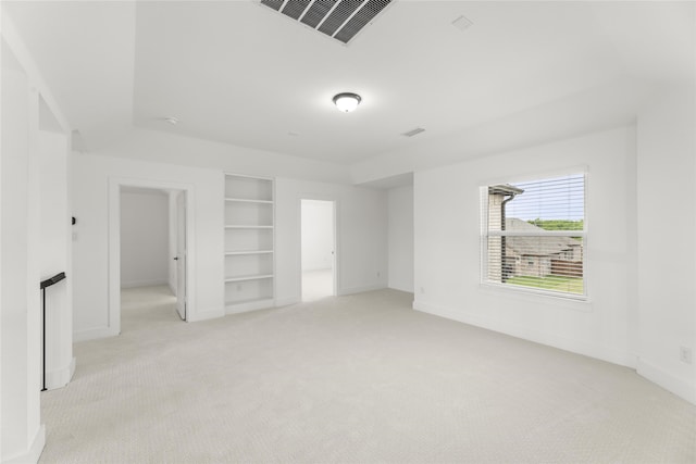 carpeted empty room featuring built in shelves