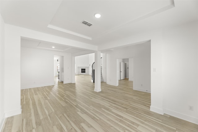 unfurnished room featuring light hardwood / wood-style flooring and a raised ceiling