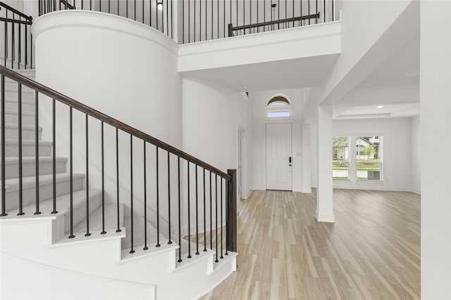 entryway with a towering ceiling and light hardwood / wood-style floors