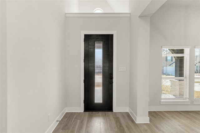 foyer featuring baseboards, elevator, and wood finished floors