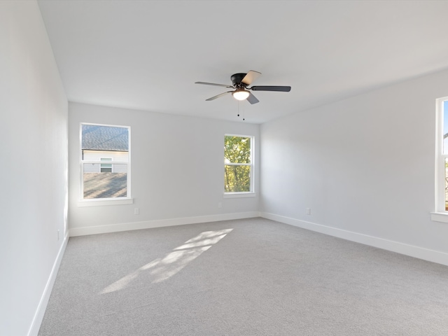 carpeted spare room with ceiling fan