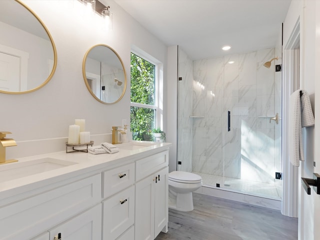 bathroom featuring walk in shower, vanity, hardwood / wood-style floors, and toilet