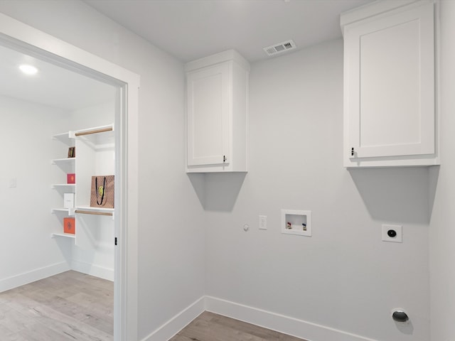 laundry area with cabinets, electric dryer hookup, hookup for a washing machine, hookup for a gas dryer, and light wood-type flooring