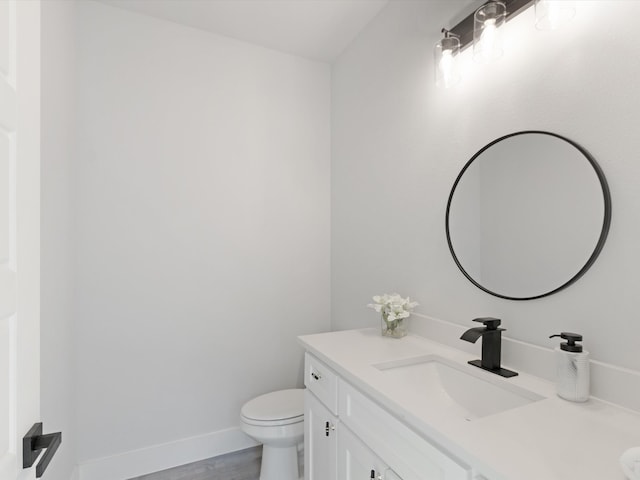 bathroom with hardwood / wood-style floors, vanity, and toilet