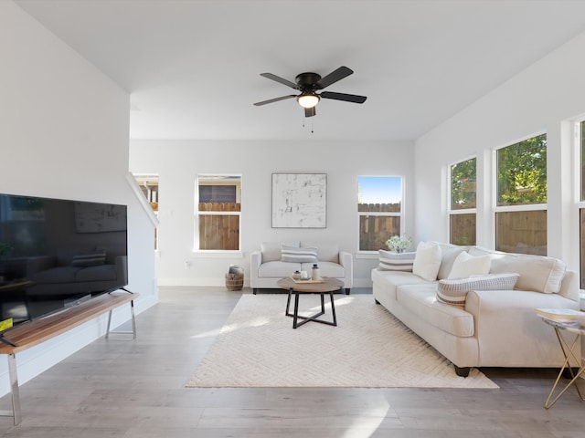 living room featuring ceiling fan and light hardwood / wood-style floors