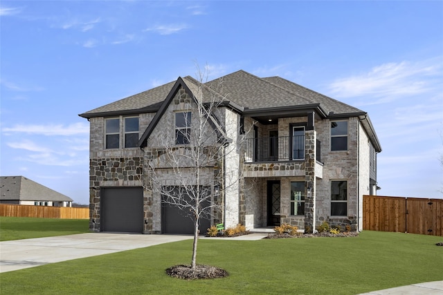 view of front of property featuring a balcony, a garage, and a front yard