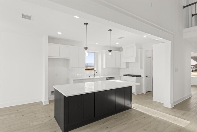 foyer entrance with a healthy amount of sunlight, light hardwood / wood-style flooring, and a high ceiling