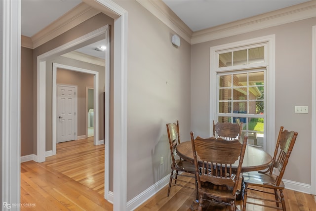 dining room with crown molding and wood-type flooring