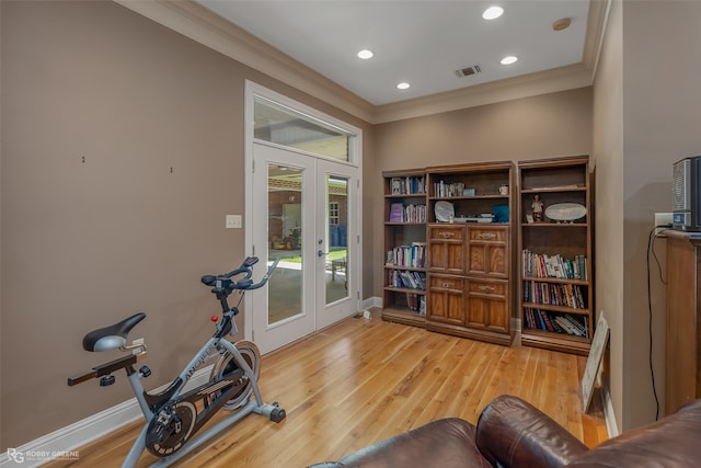 exercise area with ornamental molding, french doors, and light wood-type flooring