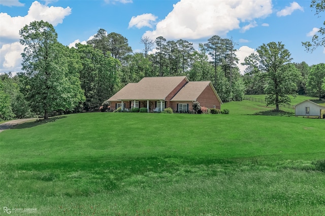 view of front of home featuring a storage shed and a front yard