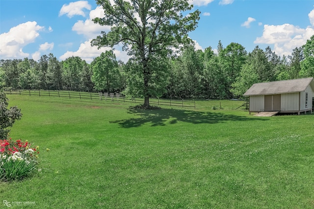 view of yard with a rural view and a storage shed