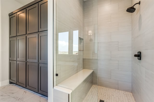 bathroom featuring tile patterned flooring and a tile shower