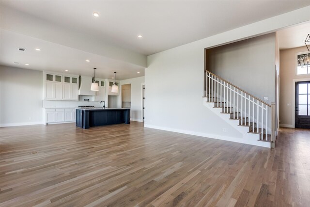 unfurnished living room featuring hardwood / wood-style flooring and sink