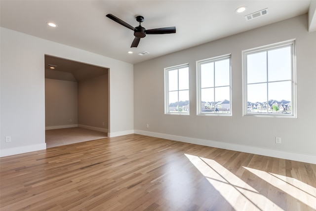 spare room with a healthy amount of sunlight, ceiling fan, and light hardwood / wood-style floors