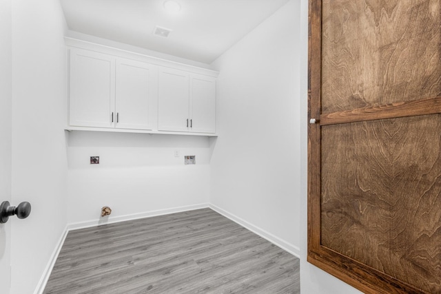 laundry area featuring hookup for a washing machine, cabinet space, light wood-style flooring, and baseboards