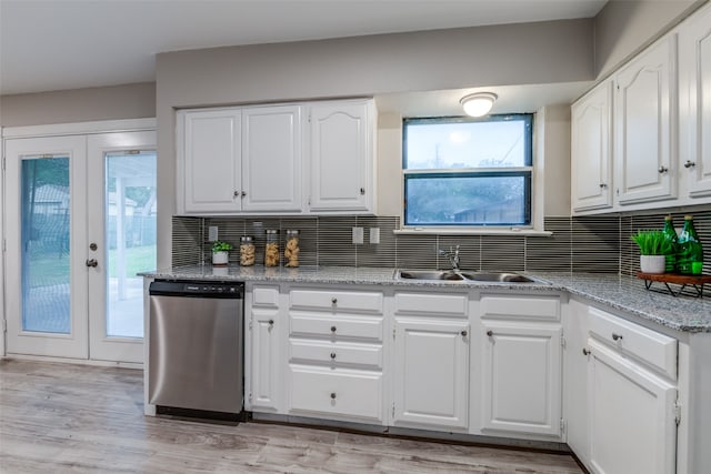 kitchen featuring stainless steel dishwasher, sink, backsplash, and white cabinets