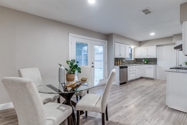 dining space with french doors and light wood-type flooring