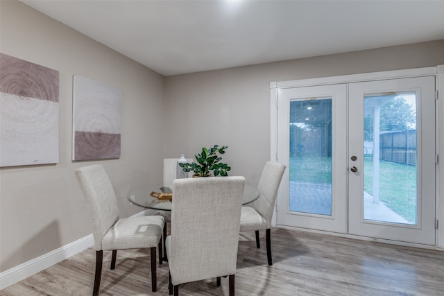 dining area featuring a wealth of natural light, light hardwood / wood-style flooring, and french doors