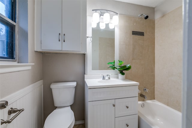 full bathroom featuring tiled shower / bath combo, vanity with extensive cabinet space, and toilet