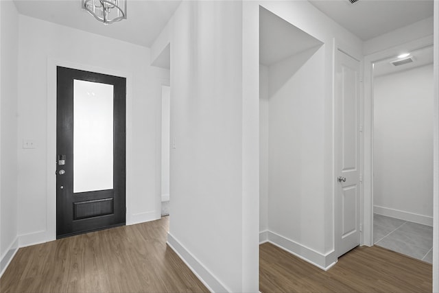 entryway featuring wood-type flooring and a chandelier