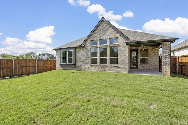 rear view of property with a yard and a patio