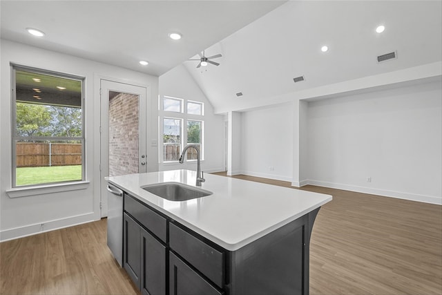 kitchen with a center island with sink, vaulted ceiling, sink, and plenty of natural light