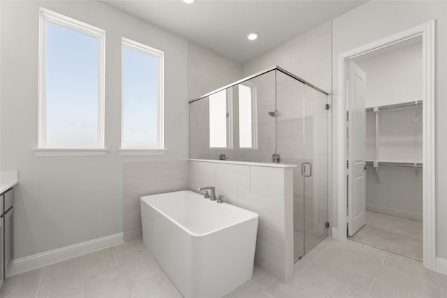 bathroom featuring vanity, plus walk in shower, and tile patterned floors