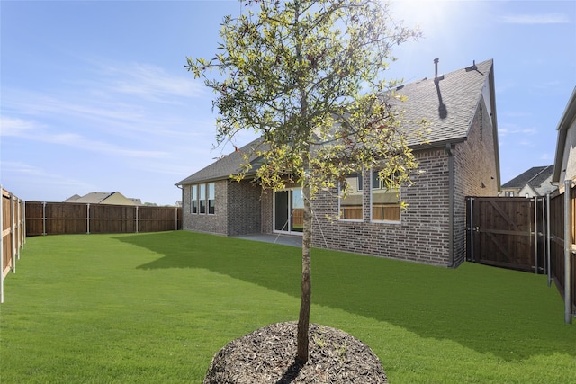 back of house with a patio area and a lawn