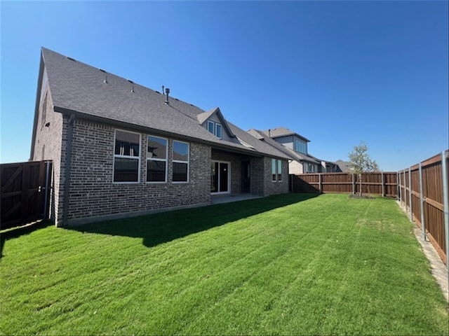 rear view of property featuring a lawn