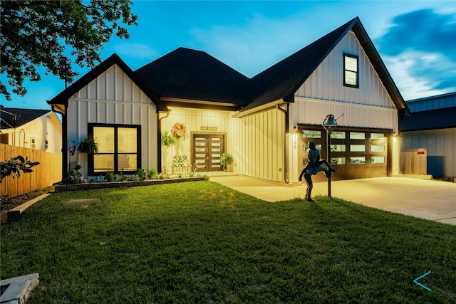 view of front of house featuring board and batten siding, a front lawn, fence, concrete driveway, and french doors