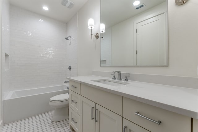 full bathroom featuring vanity, tiled shower / bath combo, and toilet