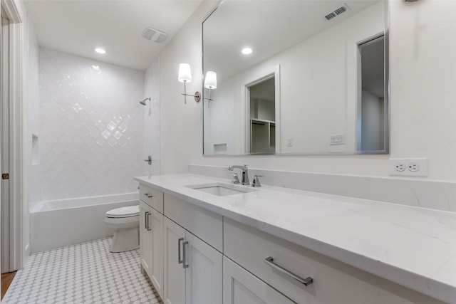 full bathroom featuring vanity, tiled shower / bath combo, and toilet