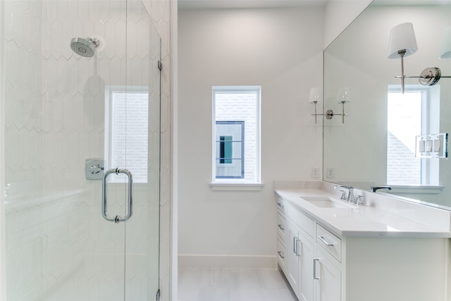 bathroom featuring a shower with door, vanity, a wealth of natural light, and tile patterned floors