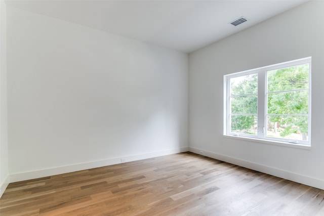 empty room with light hardwood / wood-style flooring and a wealth of natural light