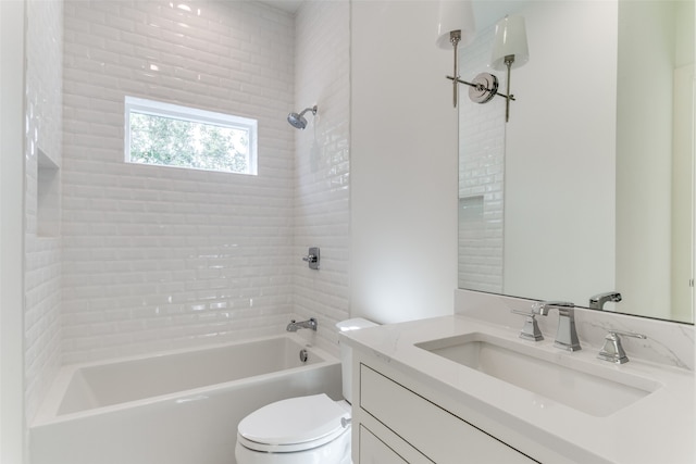 full bathroom featuring tiled shower / bath, vanity, and toilet