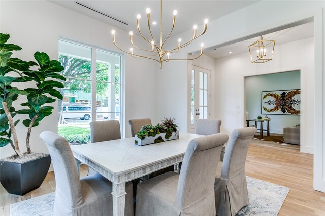 dining area with light hardwood / wood-style floors and french doors