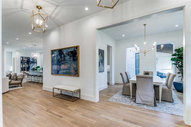 dining area with a chandelier and light hardwood / wood-style flooring