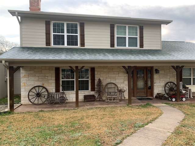 view of front facade featuring a front yard and covered porch