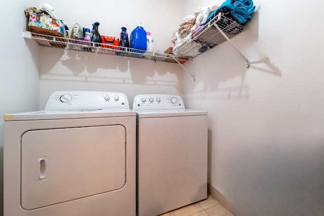 laundry room with washer and clothes dryer and light tile floors