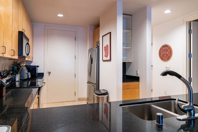 kitchen featuring kitchen peninsula, electric stove, light tile flooring, stainless steel refrigerator, and sink