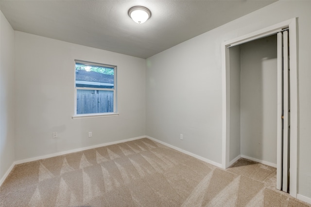 unfurnished bedroom featuring a closet and light carpet