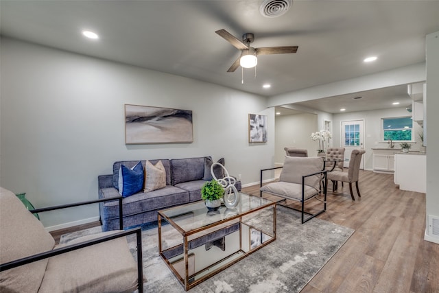 living room featuring wood-type flooring and ceiling fan