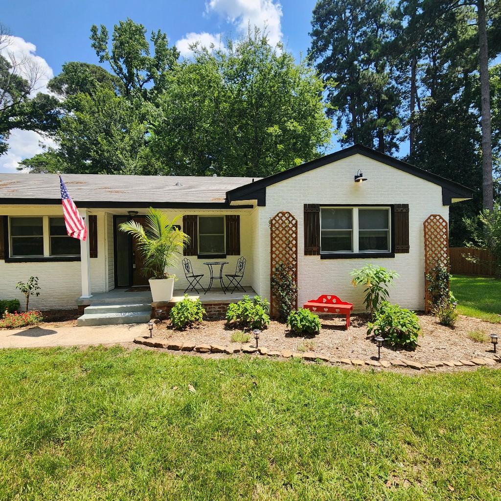 ranch-style home with a porch and a front yard