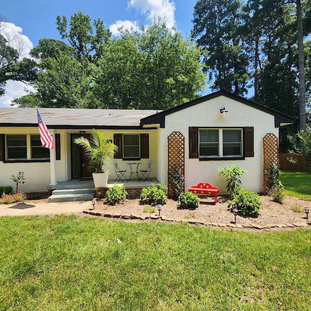 ranch-style home with a porch and a front yard