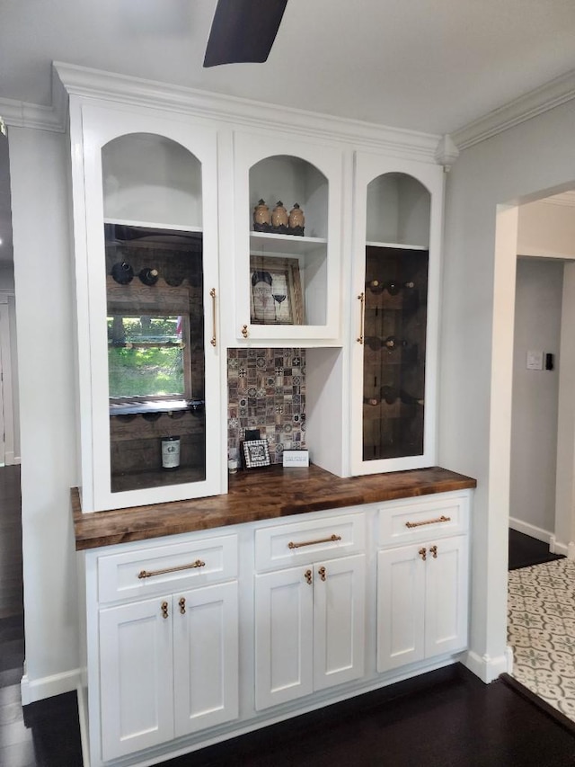 bar with white cabinetry, dark hardwood / wood-style flooring, crown molding, and wood counters