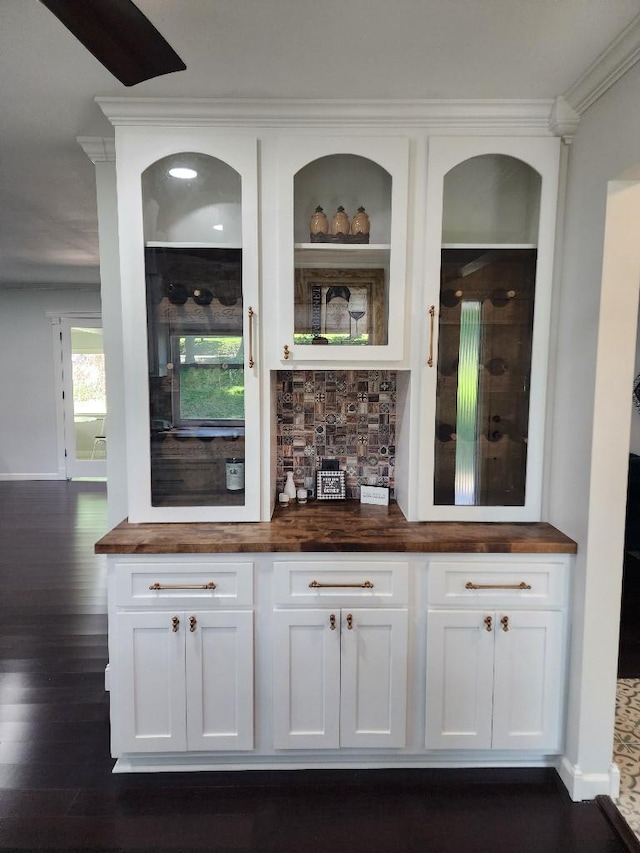 bar with butcher block countertops, white cabinetry, backsplash, ornamental molding, and dark wood-type flooring