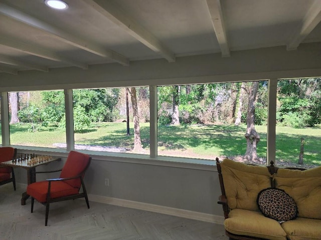 sunroom / solarium featuring beamed ceiling