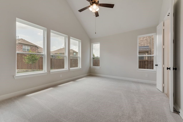 empty room featuring high vaulted ceiling, a ceiling fan, baseboards, and light carpet